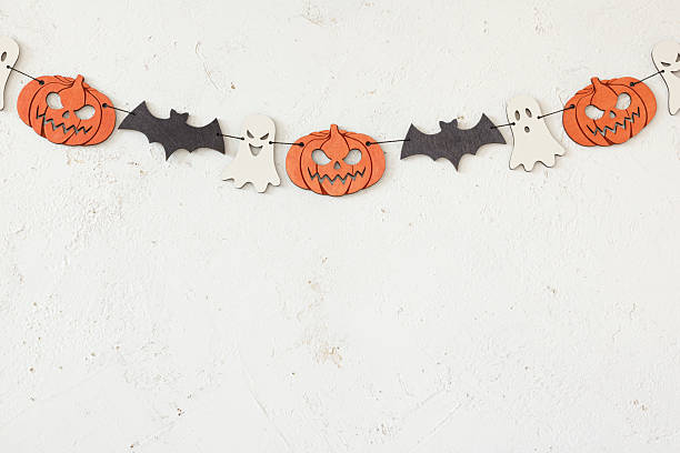 istock Halloween garland with bat, pumpkin and ghost on abstract plaster wall background 2234968611