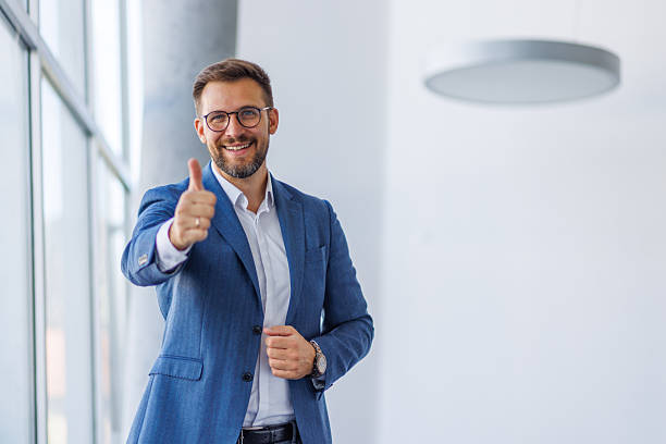 istock Businessman gesturing thumbs up sign in office 2234968676