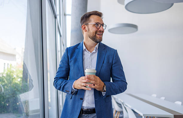 istock Businessman holding reusable coffee cup smiling looking away from camera 2234968737