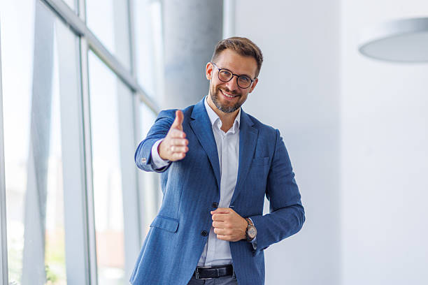 istock Smiling businessman offering handshake in modern office 2234968747