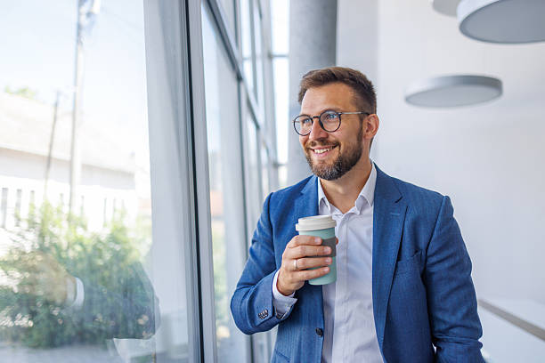 istock Businessman enjoying a coffee break looking out the window 2234968752