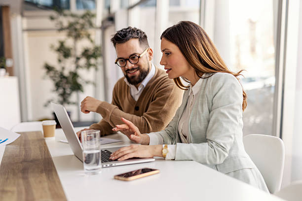 istock Focused Business Professionals Collaborating in Bright Office with Laptops and Natural Lighting 2234968897