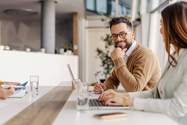 istock Business Professionals Collaborating at Modern Office Meeting Table with Laptops and Natural Light 2234968910