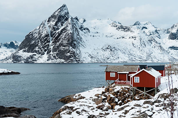 istock Red cabins by a snowy mountain lake 2234970039