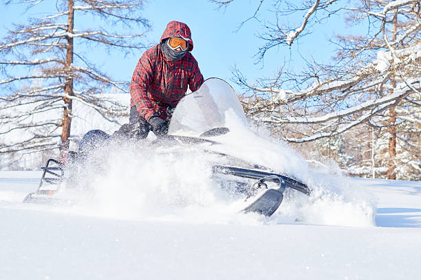 istock Young Man Riding Snowmobile through Snow Covered Winter Landscape 2234970708