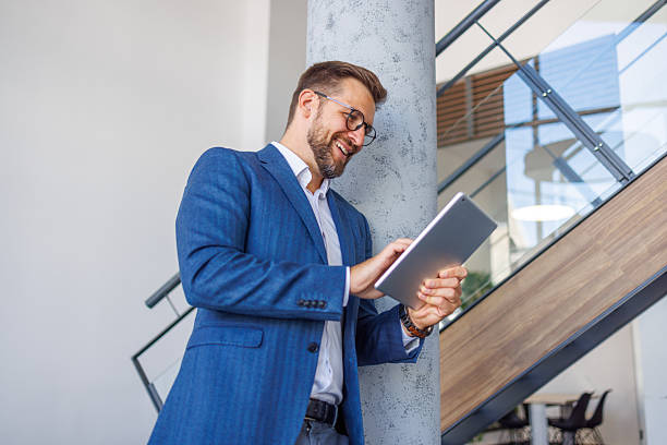 istock Smiling businessman using digital tablet in modern office 2234971965