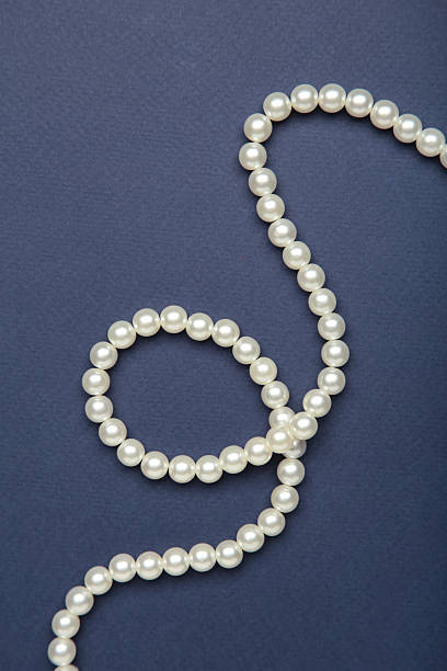 istock Elegant pearl necklace on blue background, top view. 2234973553