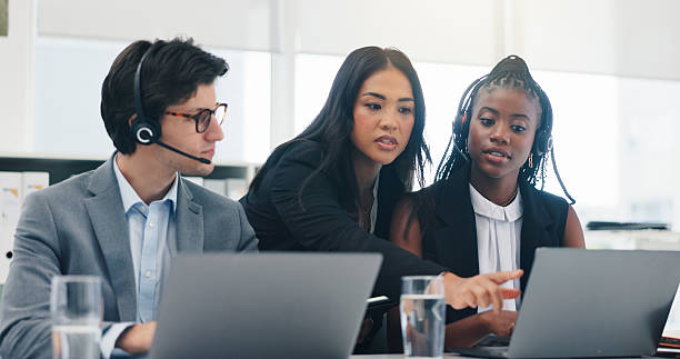 istock Coaching, call center and people with laptop, help and training staff with conversation. Employees, group and mentor in workplace, computer and advice with customer service, discussion and contact 2234978234