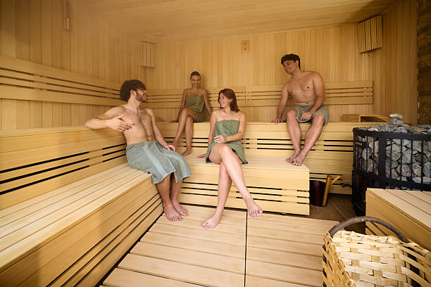 Young happy couples communicating while spending a relaxing day in the sauna.