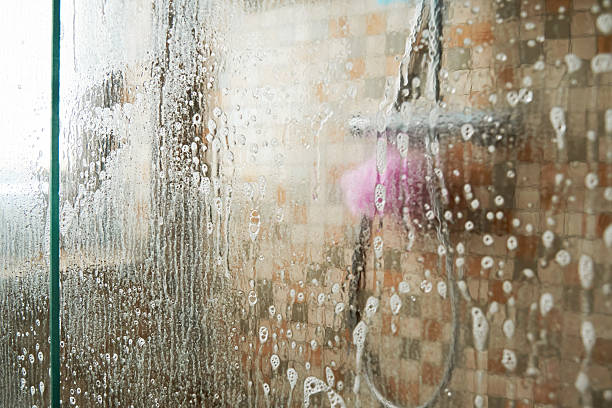 istock Shower cabin glass wall is completely covered in limescale and water drops 2234984300