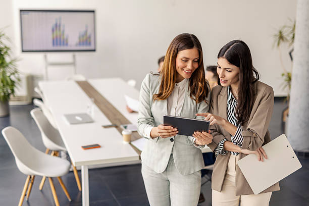 istock Businesswomen Discussing Data on Tablet in Contemporary Office with Open Workspace 2234988257