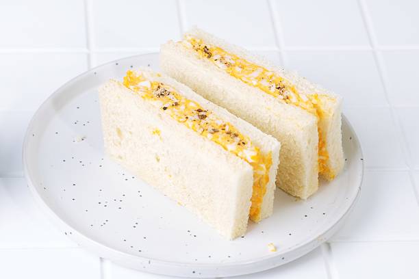 Japanese tamago sando sandwich cut to show egg salad filling. Authentic Asian breakfast or snack food.