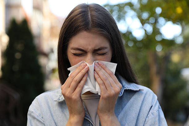 istock Young woman with runny nose in park 2234993044