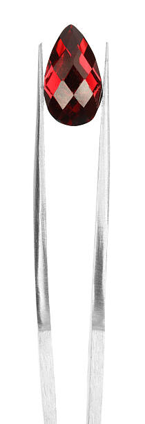 istock Tweezers with shiny red gemstone isolated on white 2234994101