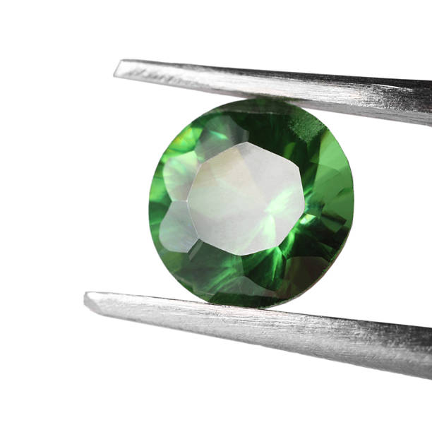 istock Tweezers with shiny green gemstone isolated on white 2234994132