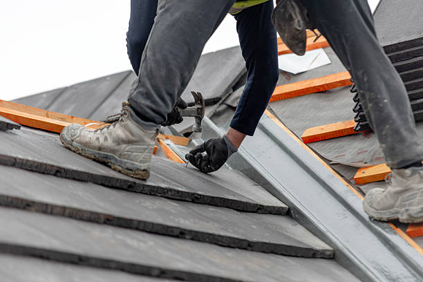 istock Construction worker carefully places roof tiles on a sloped surface while standing on top of a building  showcasing the effort involved in roofing work 2234994822
