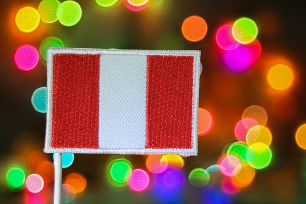 An embroidered patch of the Peru national flag displayed against a vibrant rainbow bokeh background that mimics fireworks. The creamy blur creates a festive and dreamy holiday atmosphere, symbolizing New Year celebration, Christmas inspiration, and national pride. Ideal for concepts of culture, identity and unity around the world.