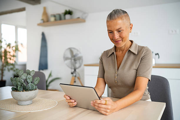 istock Smiling woman using a digital tablet at a bright, modern kitchen 2234996715