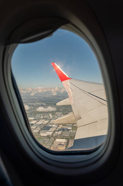 istock Airplane wing seen through window flying over agricultural fields 2234998556