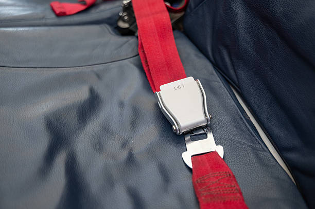 istock Red airplane seat belt fastened on blue leather seat 2234998810