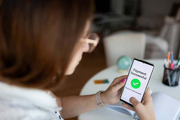 istock Young Woman Making Online Transaction via Mobile App 2234999823