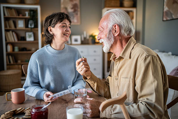 istock Nurse assisting senior man taking medication at home 2235000451