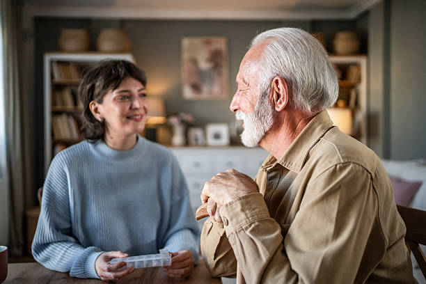 istock Nurse assisting elderly man with medication at home 2235000474