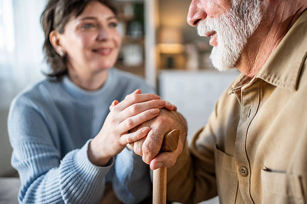 istock Nurse supporting senior man holding walking stick at home 2235000508