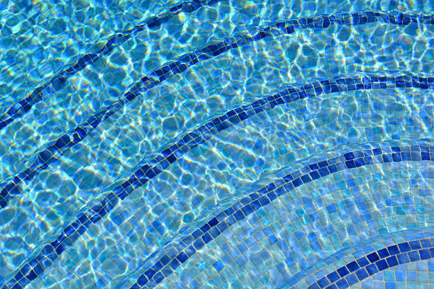 Crystal clear water with ripples in a blue tiled swimming pool, summer holiday vibes
