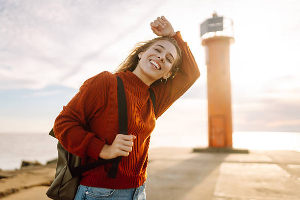 istock Happy woman having fun on the pier with a lighthouse. 2235001751