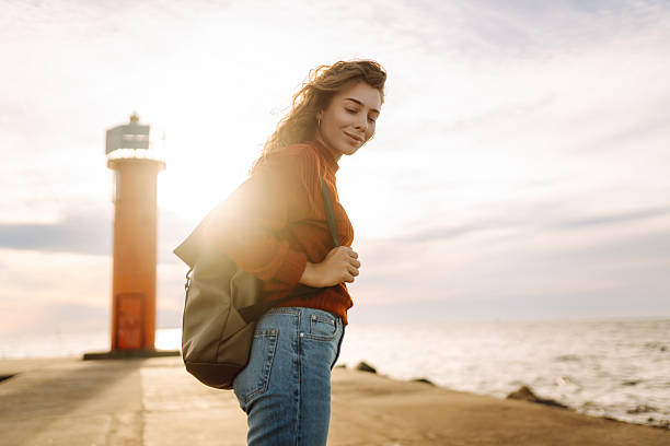 istock Happy woman having fun on the pier with a lighthouse. 2235001764