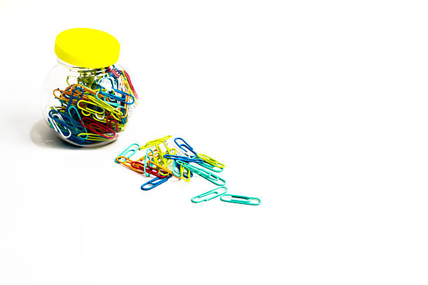 istock Colorful paper clips in a jar with some spilled out, studio shot on white background 2235002906