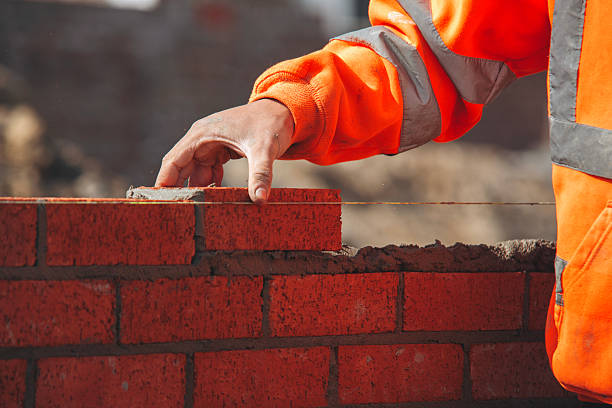 istock Close-up of Bricklayer laying red bricks on building site 2235002991