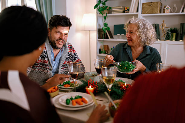 istock Family members passing dishes at holiday dinner table 2235003610