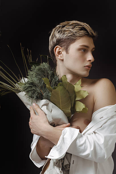 istock Stylish Young Man Holding A Greenery Bouquet Against Dark Background 2235003722