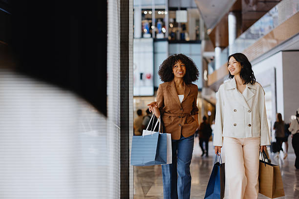 istock Two young women walking and shopping in a mall 2235007009