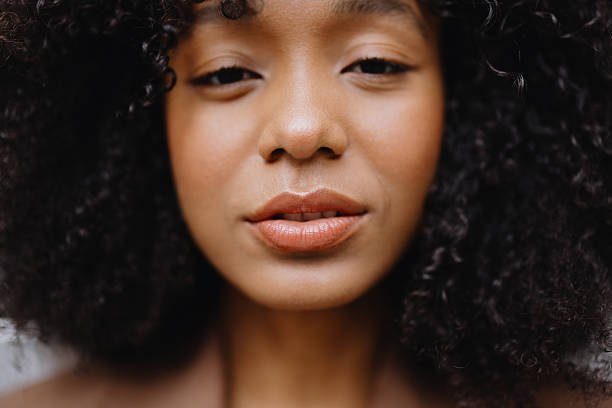 Close-up portrait featuring a young woman with beautiful afro hair and captivating brown eyes, radiating confidence and natural beauty