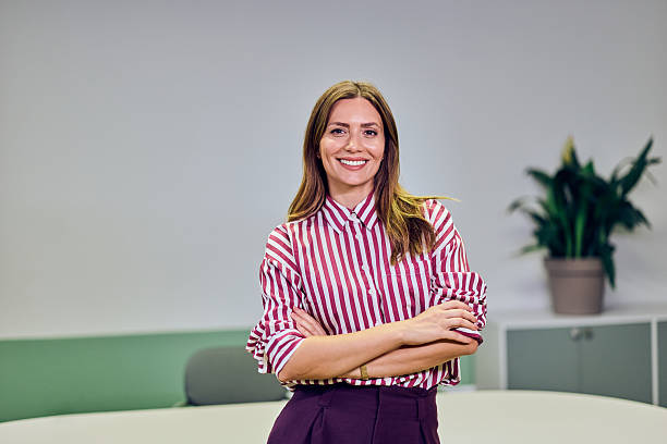 istock Confident Woman in Striped Shirt Posing in a Modern Office Environment 2235007474