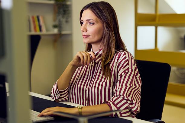 istock Professional Woman at Her Office Desk Focused on Work in Modern Workspace 2235007501