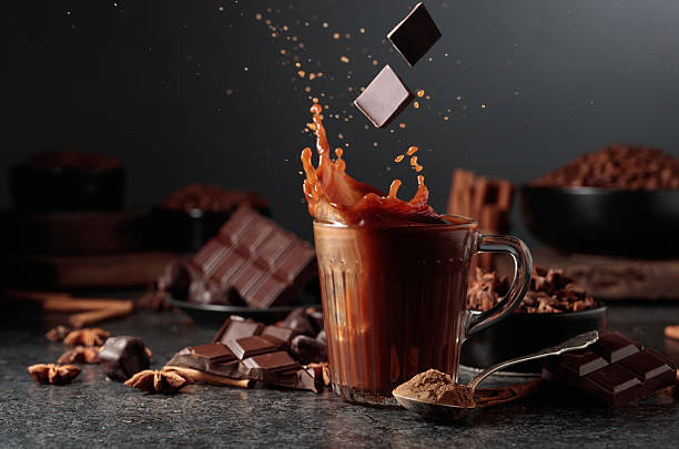 istock Pieces of dark chocolate fall into a mug of cocoa drink. 2235007656