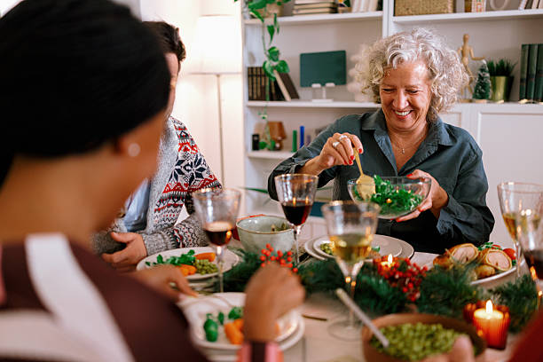Family members passing dishes at holiday dinner table
