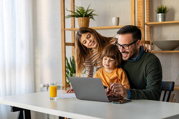 istock Father with kids having fun online with application watching video cartoon or playing game on laptop 2235011108