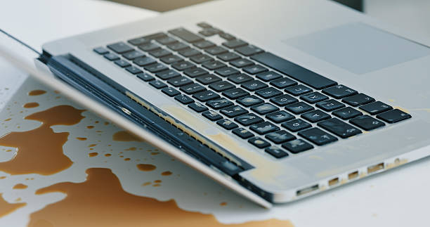 istock Laptop, coffee and spill liquid in office for accident, work chaos and keyboard damage. Takeaway, pc and messed drink on tech with clumsy problem, electronic insurance and hazard of beverage disaster 2235011603