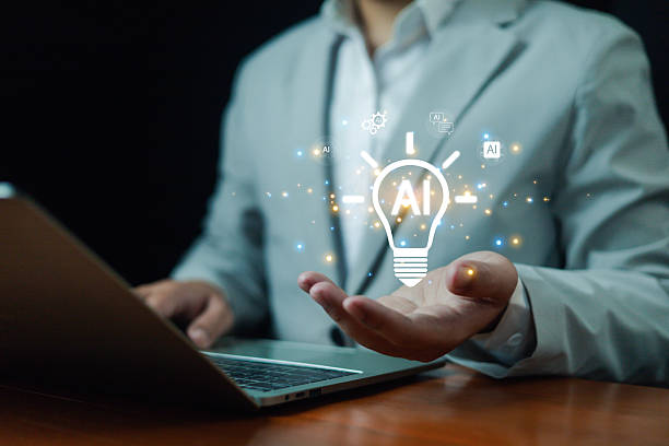 istock Businessman using laptop with glowing AI light bulb floating above hand, symbolizing artificial intelligence, innovation, digital technology, smart solutions, and future business development. 2235011733