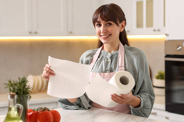istock Smiling woman using paper towels at white marble table in kitchen 2235011831