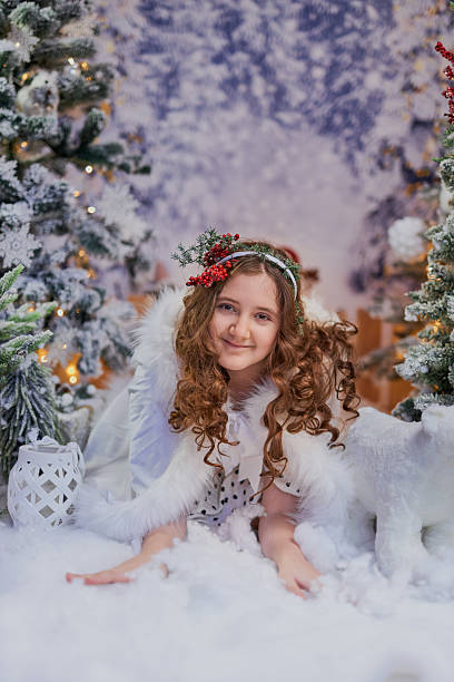 christmas angel on blur bokeh city lights at night on background. Little white guardian angel in snow. Christmas decoration