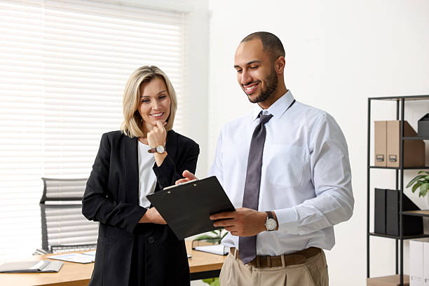 istock Coworkers with clipboard working together in office 2235013770