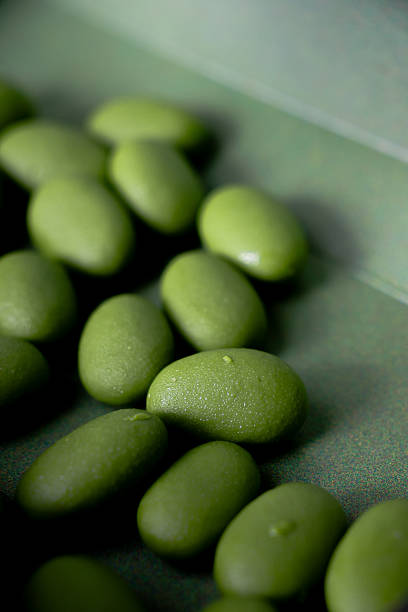 istock Several almond chocolates are oblong and coated with a smooth, glossy, green matcha layer. 2235016546