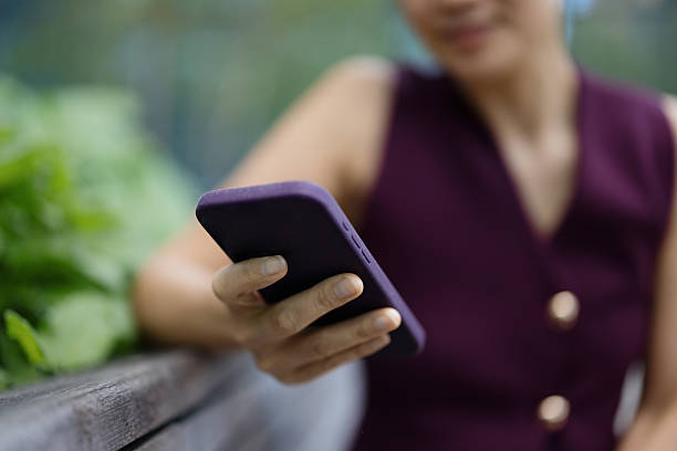 Businesswoman using Apple iPhone 12 Pro Max with purple case