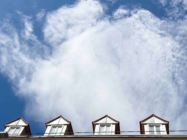 Rooftop dormers against a cloudy sky